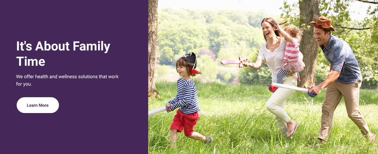Text reading 'It's all about family time and we offer health and wellness solutions that work for you.' alongside a button reading 'Learn More' and a photograph to the right showing a happy family playing together.